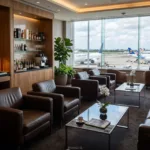 Pessoa segurando cartões de alta renda sobre mesa de aeroporto